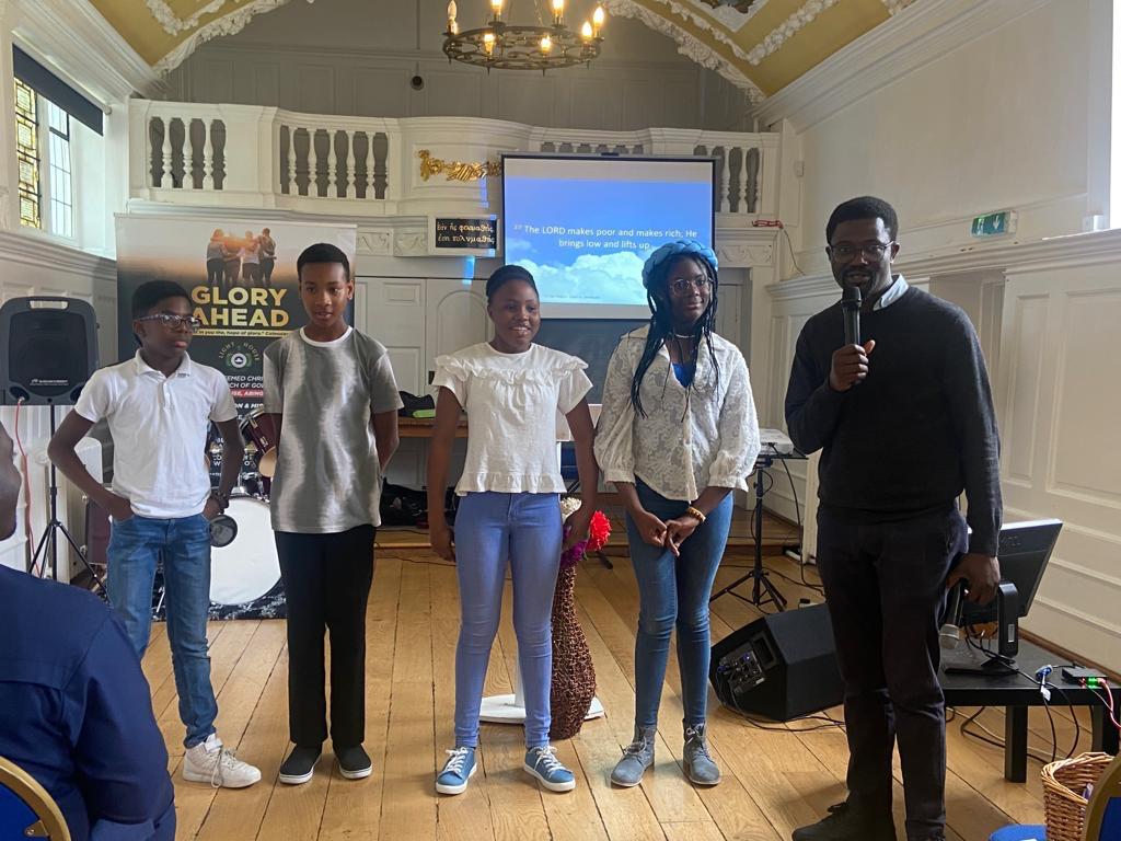 Youth ministry presentation with four young people standing at the front of church